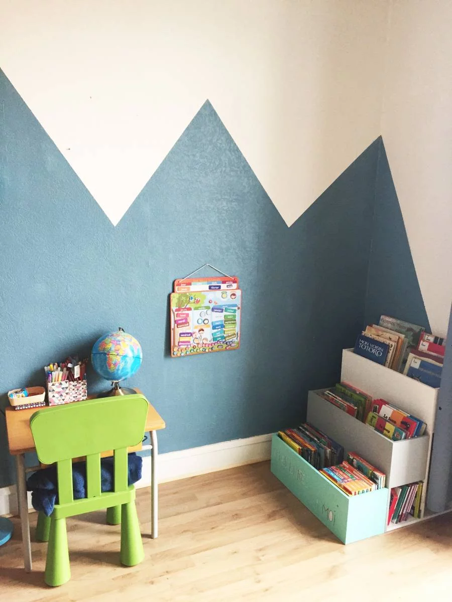 Coin lecture et rangement à hauteur d'enfant avec étagères murales et meuble en forme de maison