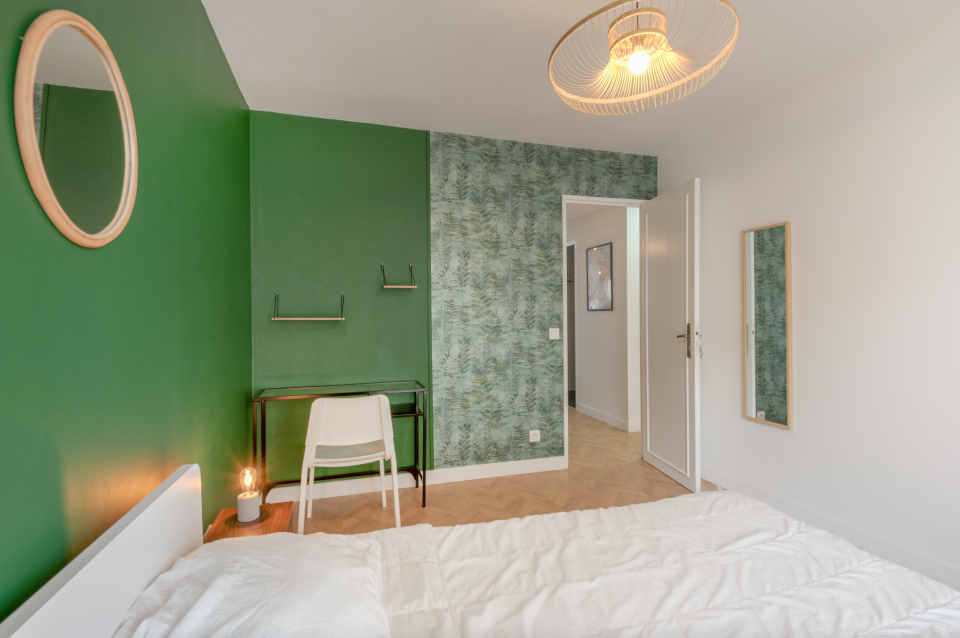 Mur vert avec papier peint végétal et sol bois chevron, décoration intérieure naturelle