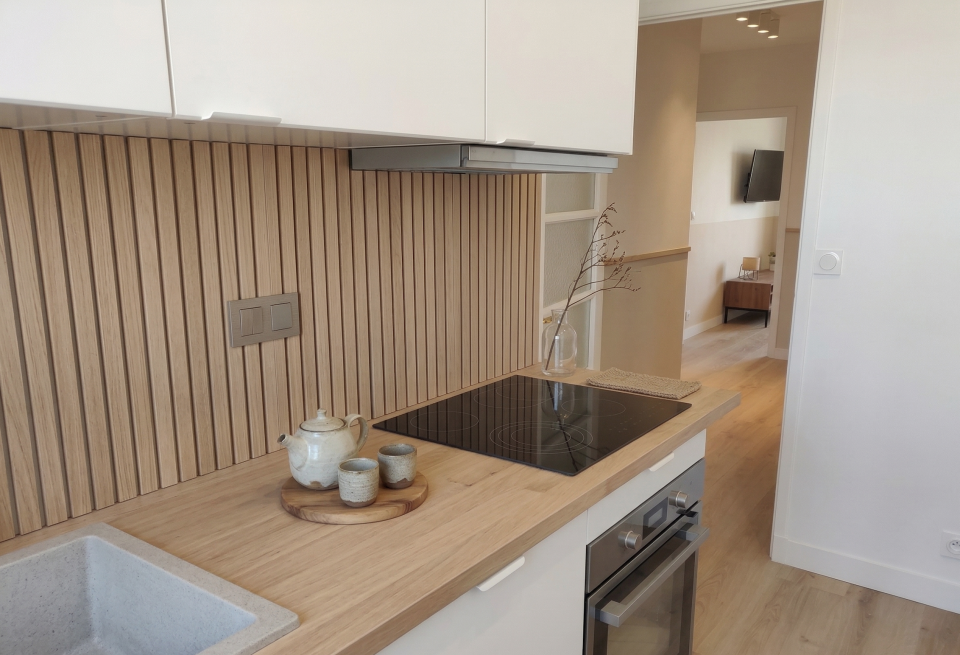 Cuisine aménagée style japandi, façades bois clair et plan de travail naturel, minimalisme fonctionnel