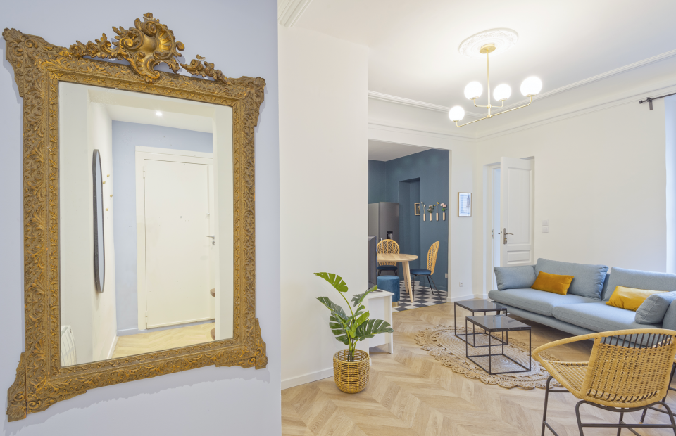 Miroir ancien dans entrée appartement haussmannien, composition miroir cadre bois sur mur d'entrée
