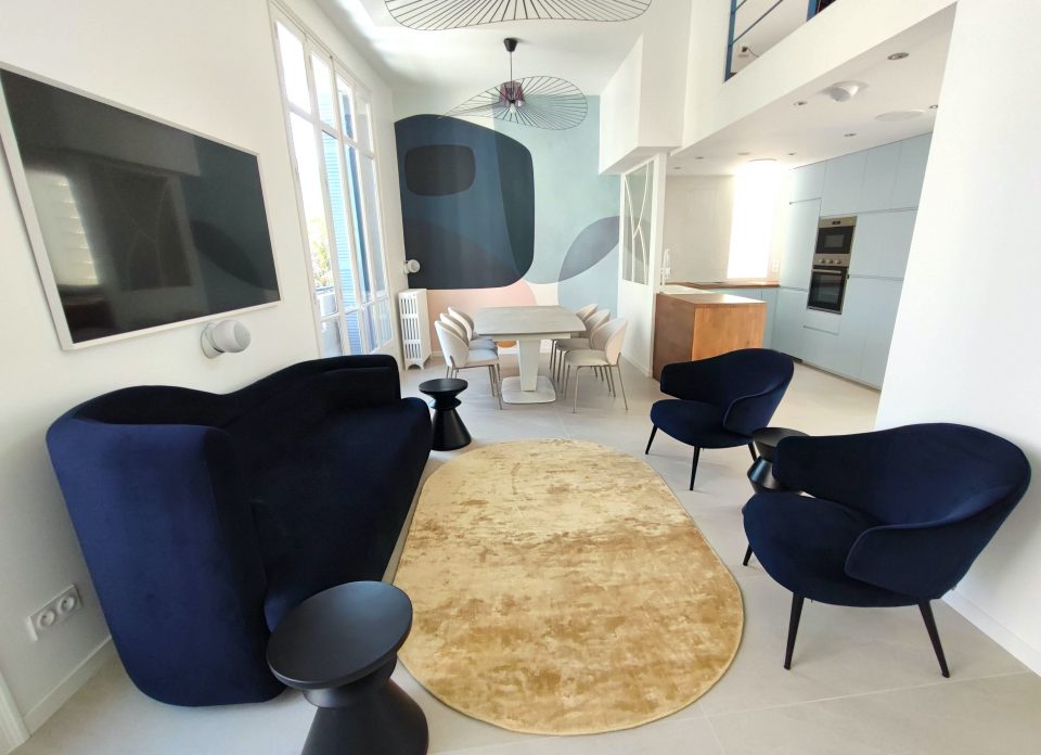 Télévision effet tableau intégrée dans un salon rénové avec système audio réparti