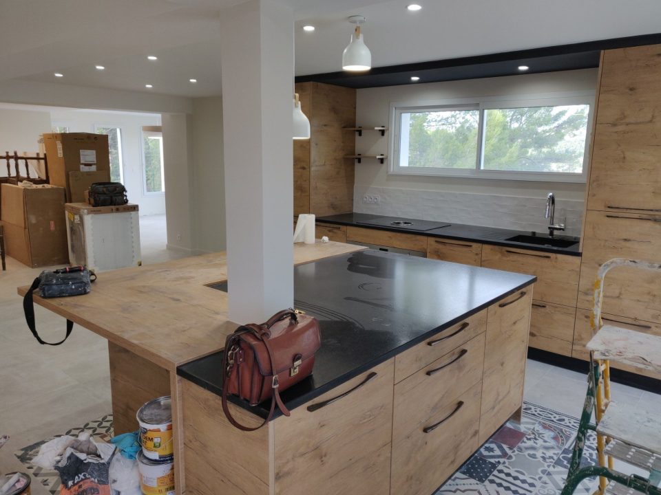 ilot central cuisine bois clair et plan noir avec poteau intégré