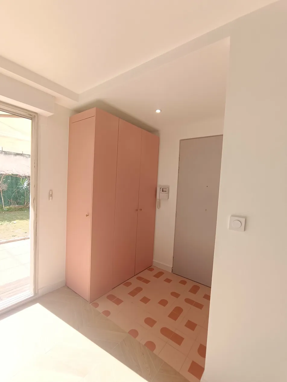 entrée appartement après rénovation, meuble sur mesure avec banquette et rangements, tapis carrelé coloré et spot faux plafond soffit