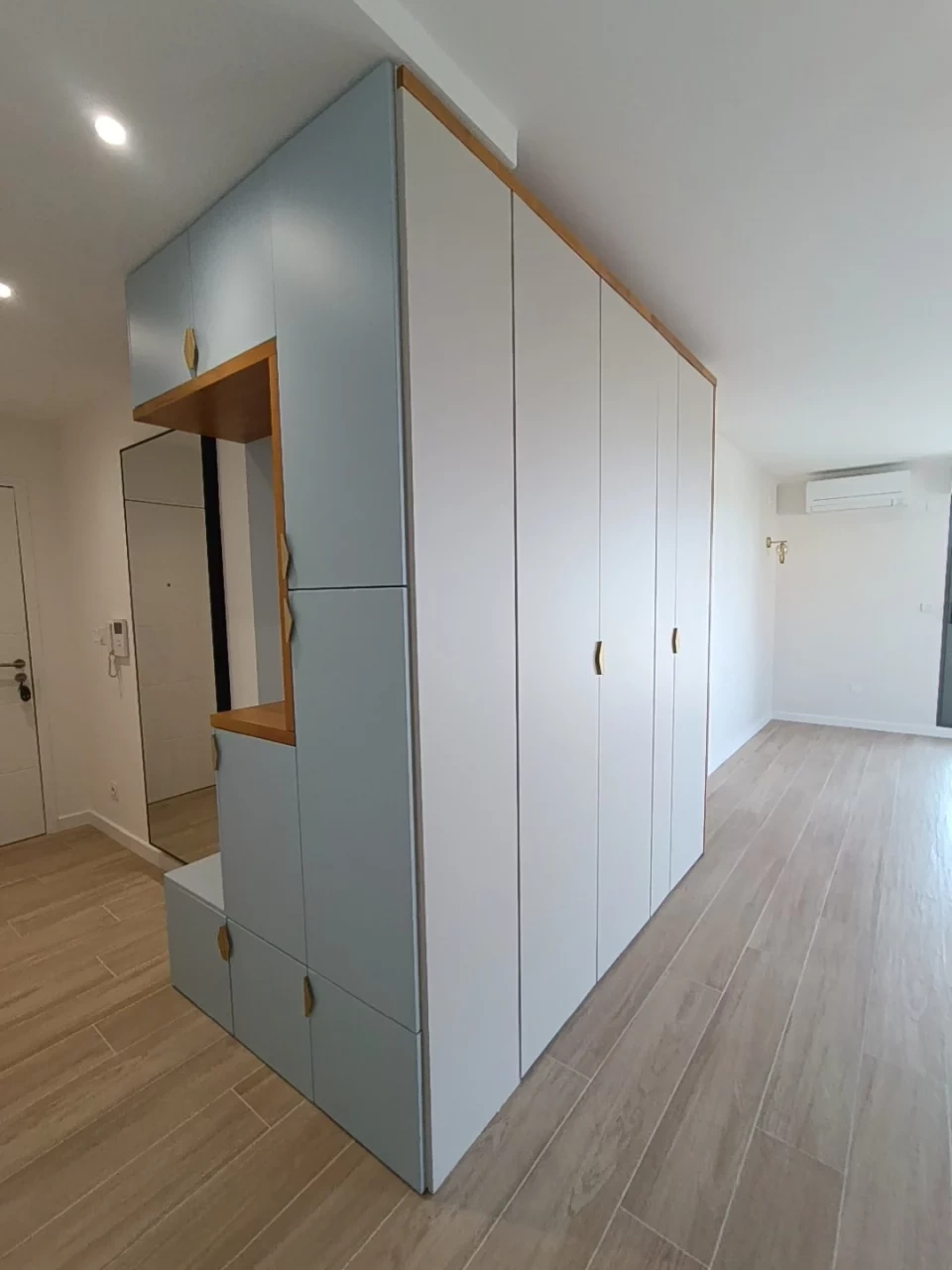 Finished hallway entryway: custom built-in storage unit, bench seat, full-height mirror and solid wood trim
