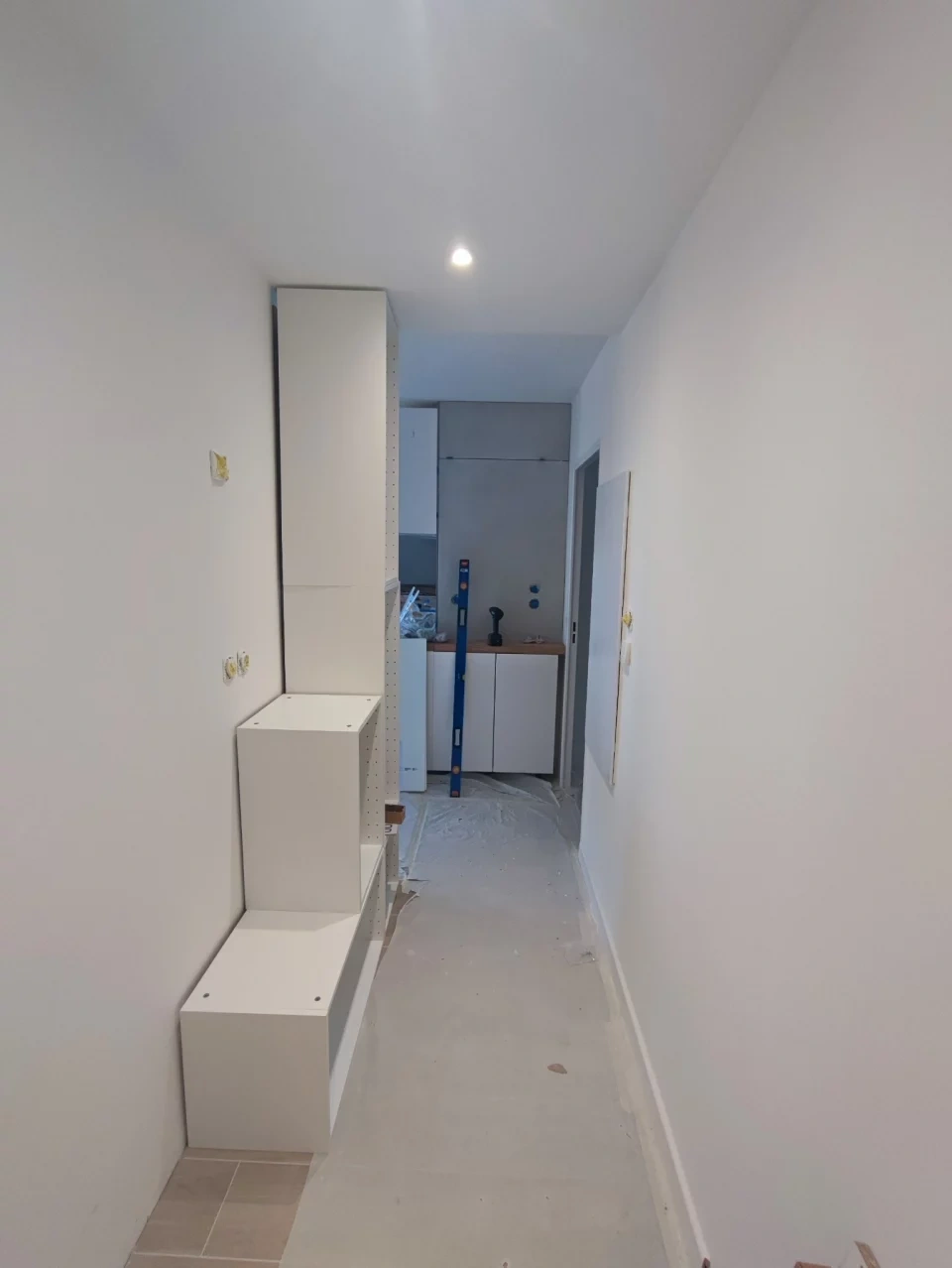 Custom hallway entryway unit installation in progress: cabinet boxes in place, door panels ready to hang