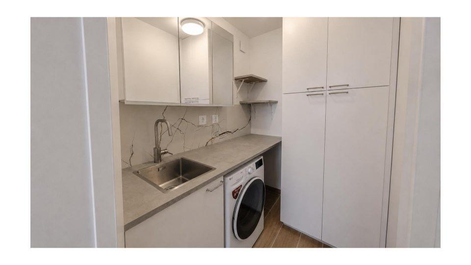 Buanderie fonctionnelle après travaux avec plan de travail, rangement et point d'eau dans un appartement